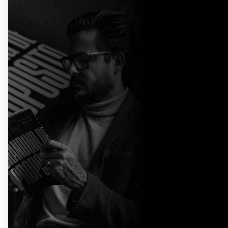 Sérgio Garb segurando um livro, em imagem do projeto original